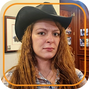 "We've Joined the Education Revolution" — photo of a young woman with a pierced lip and crimped red hair wearing a cowboy hat