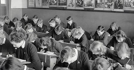 black and white photo of 1920s students at wooden desks (Education Reform: An Overview and Its Significance article)