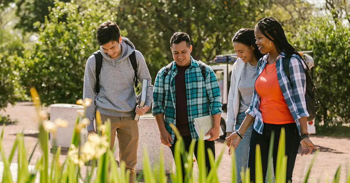 A group of college students walks together across campus (Strategies to Increase College Enrollment article)